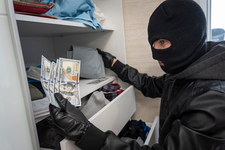 Thief stealing money from closet