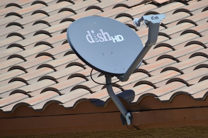 A DISH HD Network satellite TV receiver mounted on a residential home roof.