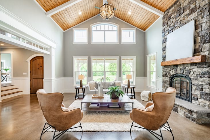 Large living room with vaulted ceiling, a fireplace, and large tv.