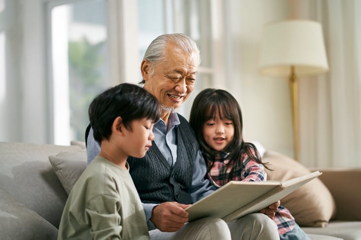 grandfather having a good time telling story to cute grandson and granddaughter