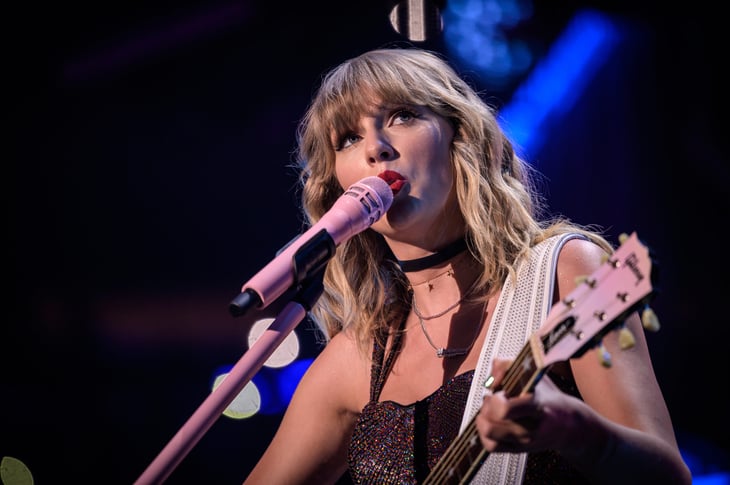 Musician Taylor Swift singing and playing guitar