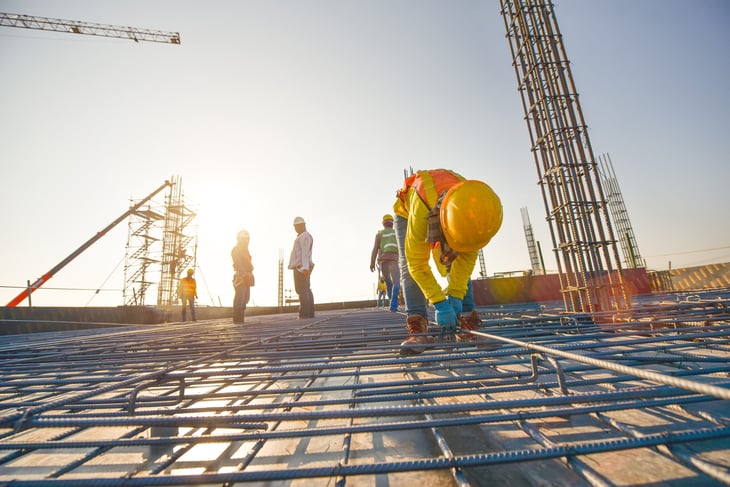 Construction workers fabricating steel reinforcement bar at a construction site