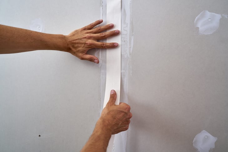 Drywall join tape, taper construction worker.