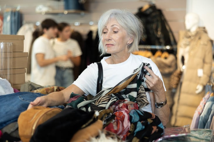 Senior shopping for secondhand clothing in a thrift store