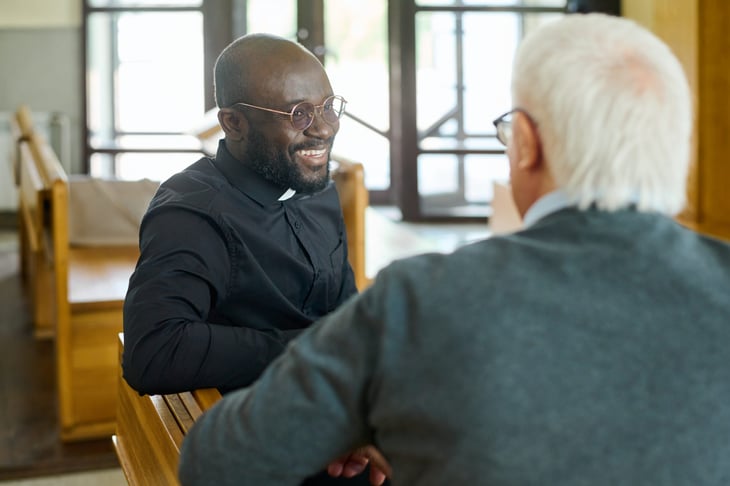 Pastor talking with a churchgoer in a pew