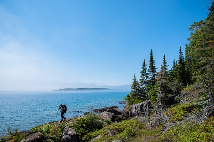 Backpacker hiking in sight of islands in Isle Royale National Park, Michigan