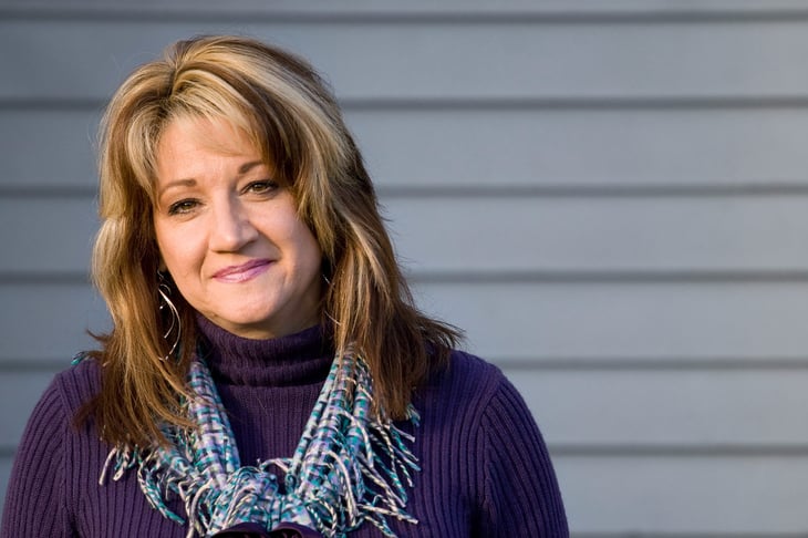 Smiling middle-aged woman outside at sunset