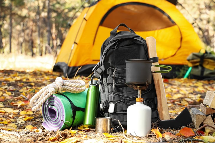 Camping gear and tent in a forest.