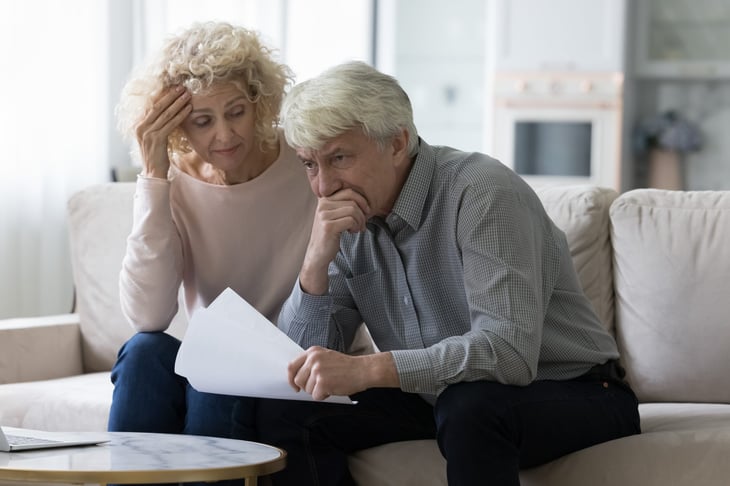Worried retired couple stressed over financial documents