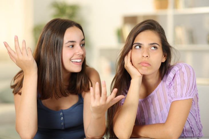 Woman rolling her eyes at her friend who is lying or exaggerating.