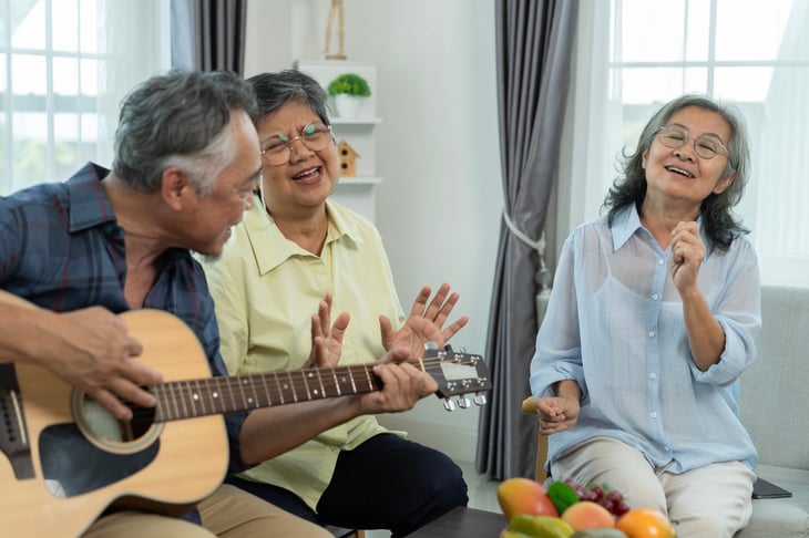Happy retirees playing music on the guitar