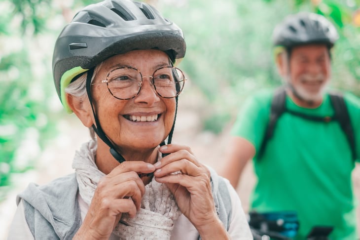 Happy senior woman in a bicycle helmet