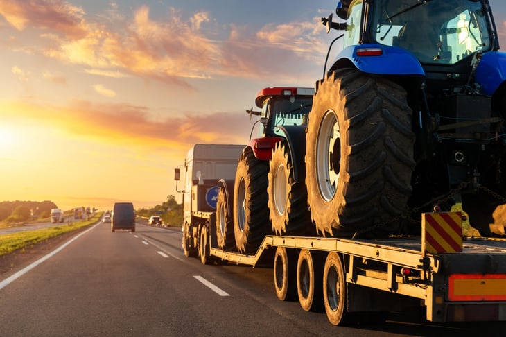 Farm machinery on a heavy industrial truck semi trailer flatbed