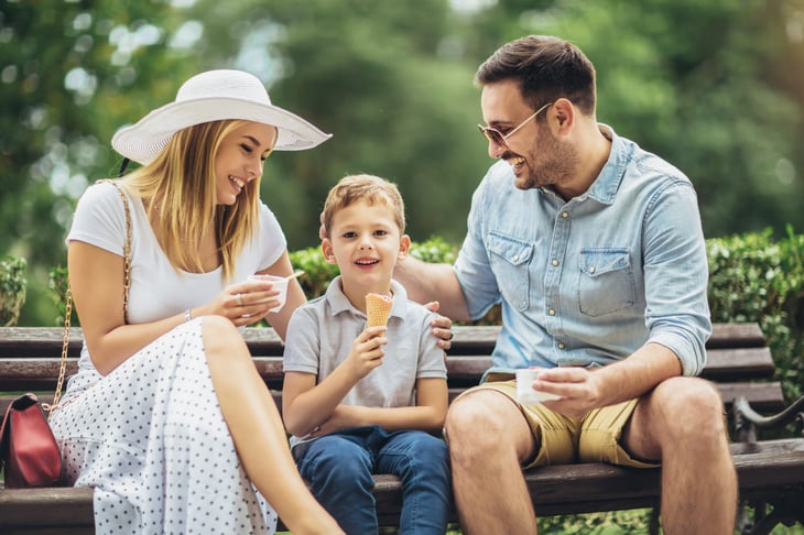 Family relaxing on a bench in a small town
