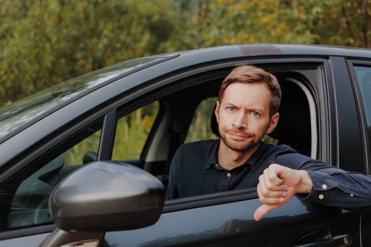 Disappointed and unhappy driver gives a thumbs down