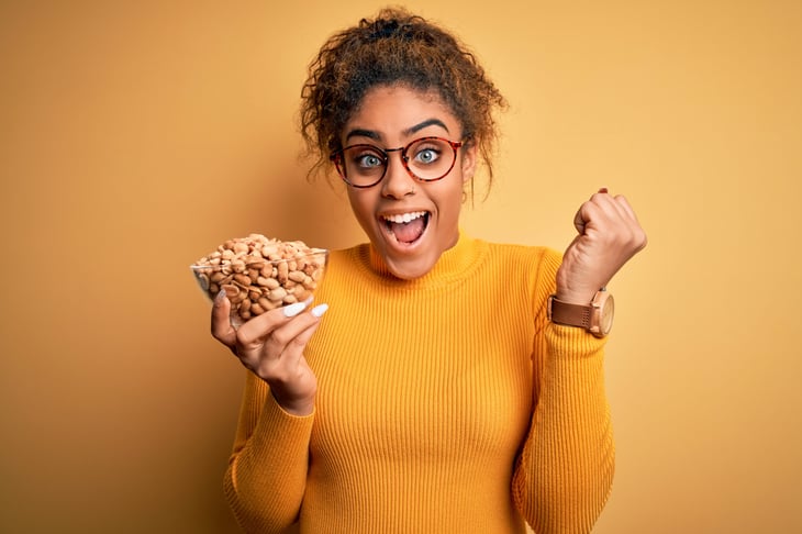 excited woman with bowl of peanuts
