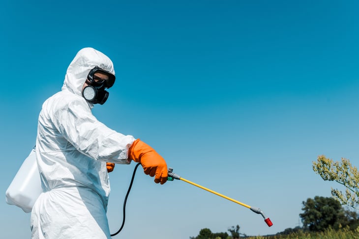 An exterminator treating someone's yard.