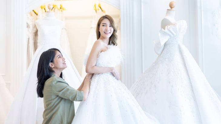 Woman trying on wedding dress for fit