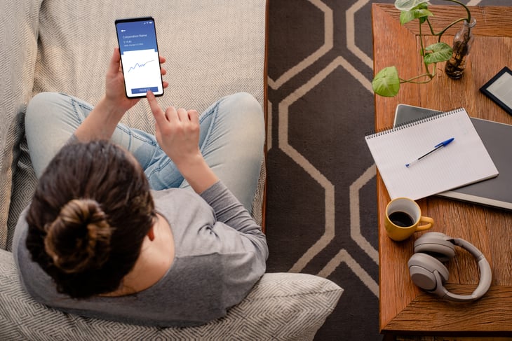 A woman checking her investments on her phone.