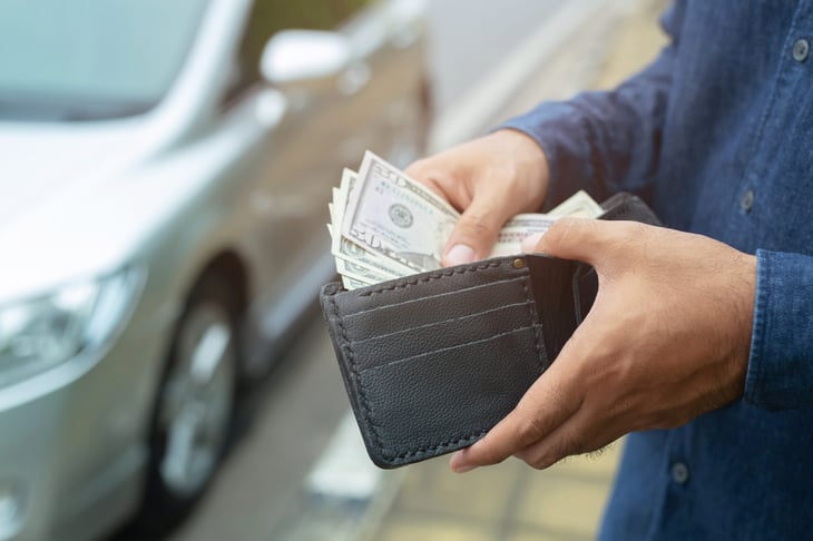 Man pulls money out of his wallet.