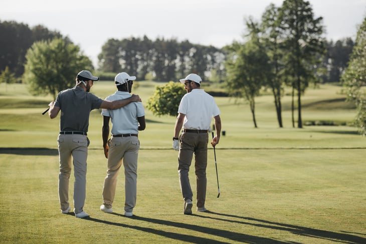 golf players hugging and walking on golf course