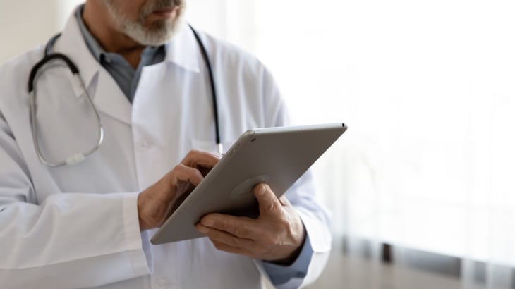 A doctor uploads patient data online.
