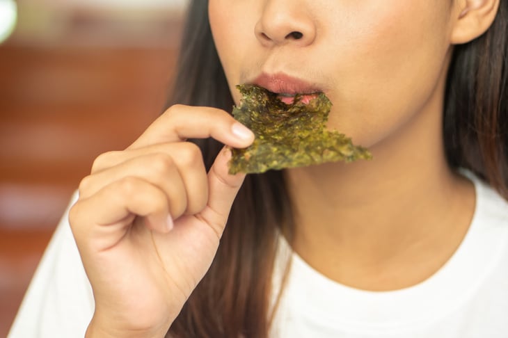 Woman eating dried seaweed