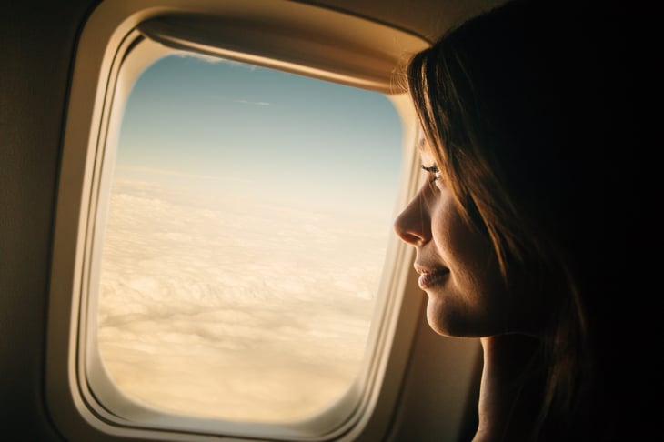 A passenger looking out the window of an airplane.