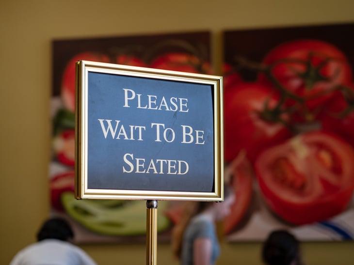 Wait to be seated sign at restaurant