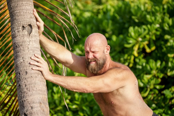 Angry Florida man pushing on a palm tree