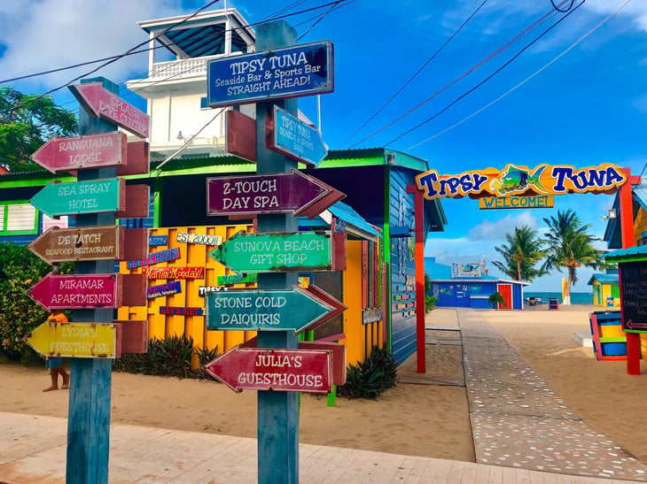 Placencia, Belize. Colorful street sign on the beachfront Sidewalk outside the Tipsy Tuna bar.