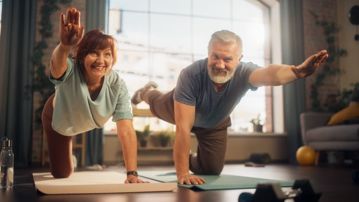 A couple does yoga in their home