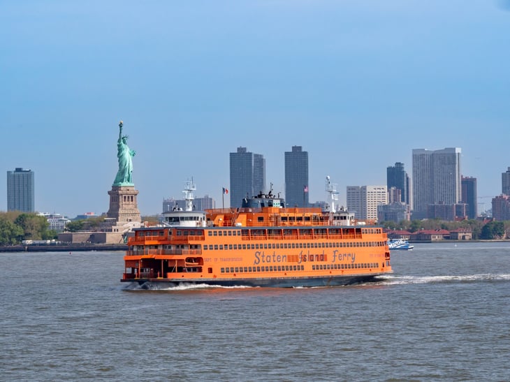 Staten Island ferry and the statue of liberty with Manhattan skyline.