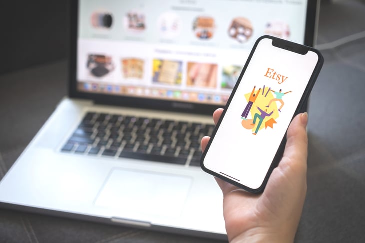 Person looking at etsy on their phone and laptop.