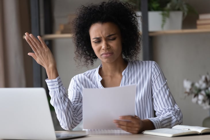 Upset woman looking at insurance cancellation letter
