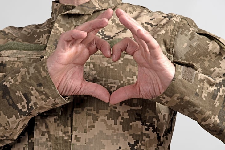 Member of U.S. Armed Forces in uniform making a heart shape