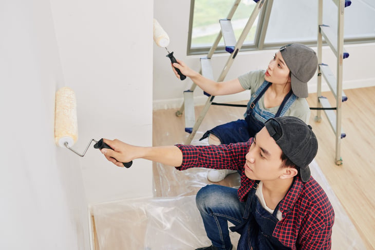 Young couple painting their home