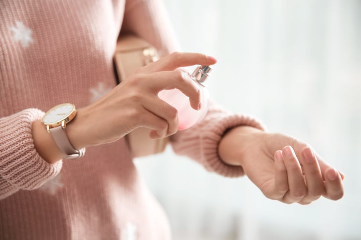 Woman spraying perfume on her wrists