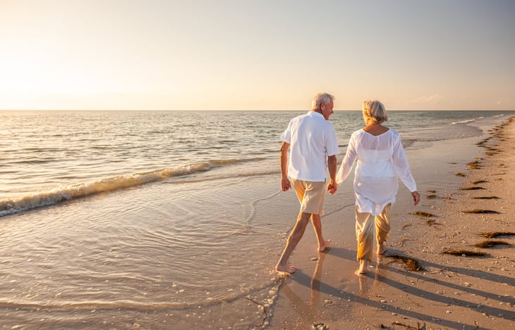 Senior couple walking on the beach.