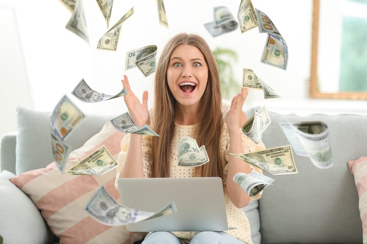 Happy homeowner surrounded by dollar bills