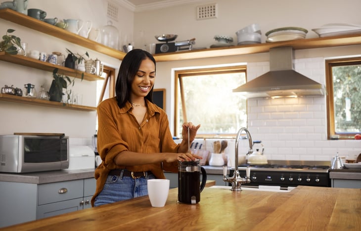 Woman with a French press in her kitchen