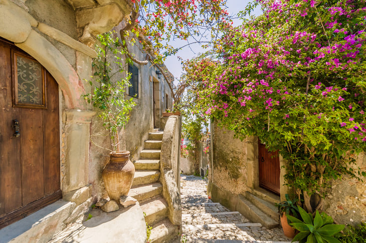 Old town path and homes with flowers in Sicily, Italy.