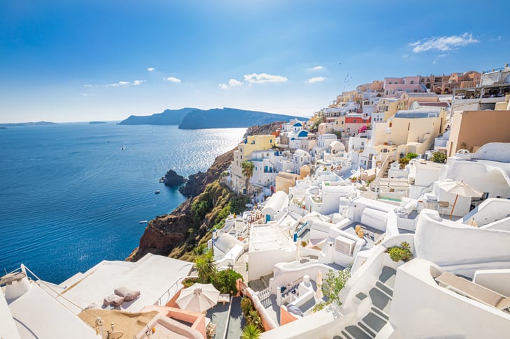 Santorini island, Greece. Traditional white architecture and Greek orthodox churches with blue domes over the Caldera.