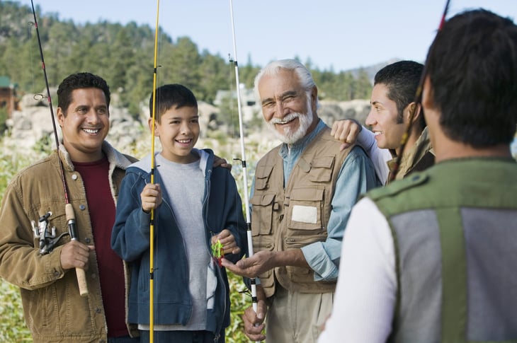 Happy senior man with sons and grandson on a fishing trip