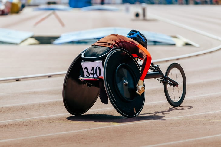 female athlete in wheelchair racing track stadium in para athletics competition, summer sports games
