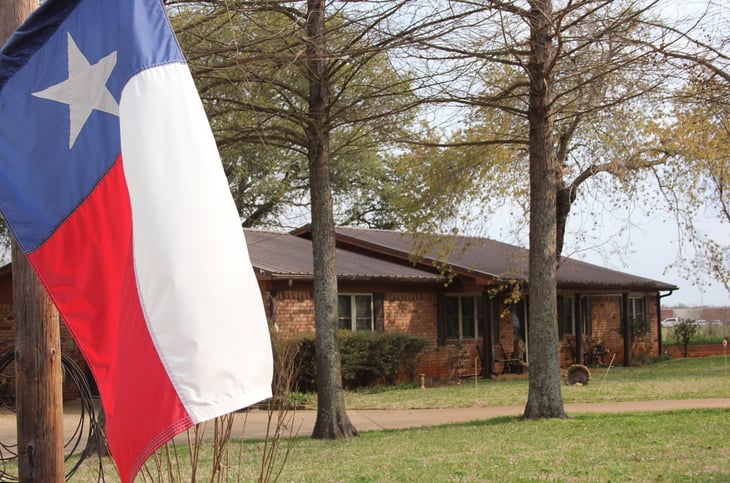 Brick ranch home with Texas flag