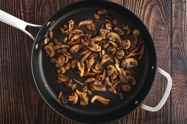 Shiitake mushrooms cooked in a pan.