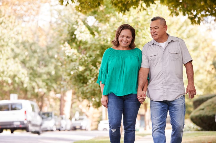 Older couple on a walk through the neighborhood.