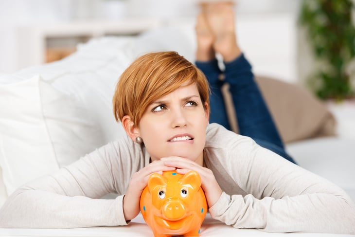Woman with a piggy bank thinking about what to do with her money