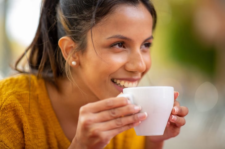 Happy woman drinking cup of coffee.